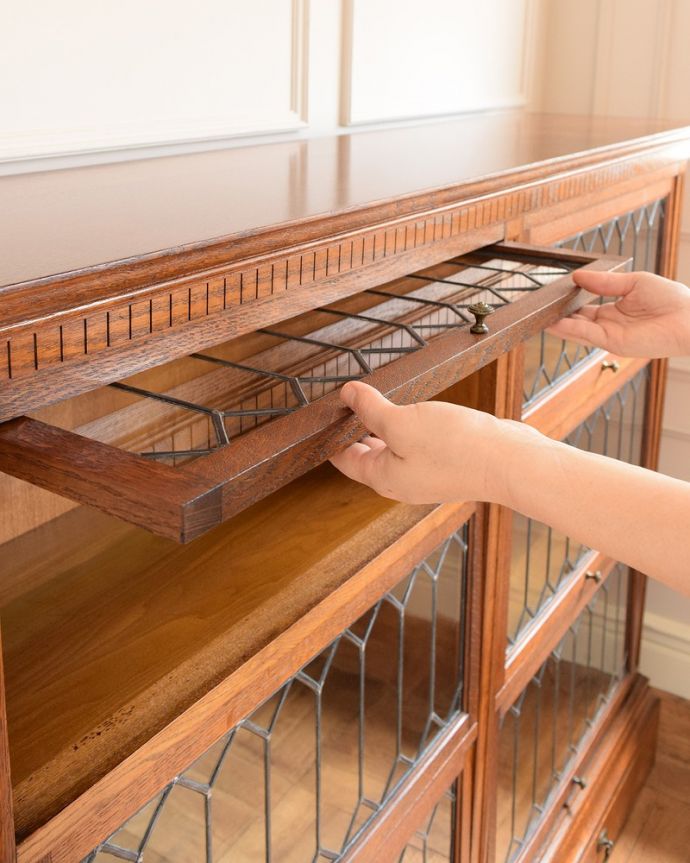 アンティーク家具 美しい格子デザインのガラス扉がキラキラ輝くアンティークの英国家具、フラップ扉のブックケース。ちょっとオシャレな扉フラップ式の扉なので、上に持ち上げてスライドさせれば中に収納出来ます。(q-1852-f)