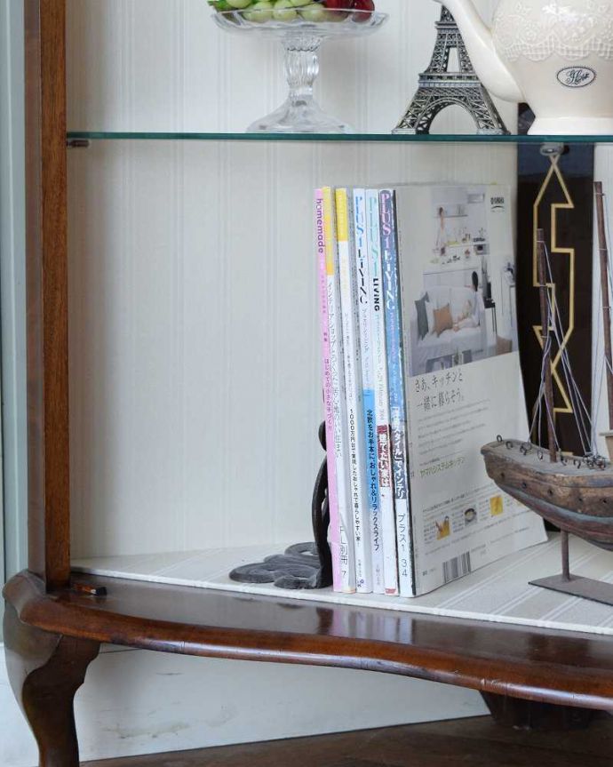 アンティークのキャビネット アンティーク家具 英国輸入のアンティーク家具、木の装飾が上品なコーナーガラスキャビネット。扉の中は収納たっぷりA4サイズの雑誌までしっかり収納出来ちゃう大きさ。(q-1874-f)