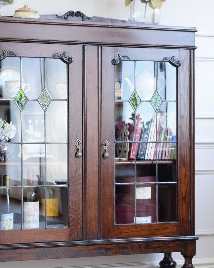 アンティークのキャビネット　アンティーク家具　美しいステンドグラスの扉、英国で見つけたアンティークガラスキャビネット（ブックケース） 。ガラス越しに中をのぞいてみると･･･アンティークのガラスを通して中に入っているものを見ると、なんだかちょっと高級に見えるんです。(q-1934-f)