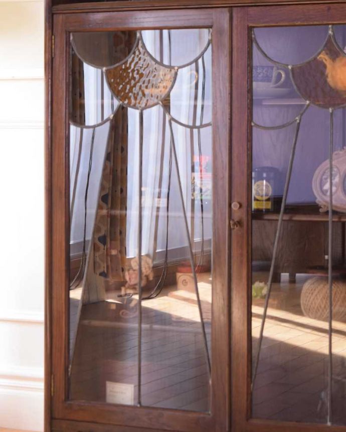 アンティークのキャビネット　アンティーク家具　美しいステンドグラスの扉、英国アンティーク家具のブックケース（本棚）。ガラス越しに中をのぞいてみると･･･アンティークのガラスを通して中に入っているものを見ると、なんだかちょっと高級に見えるんです。(q-1952-f)