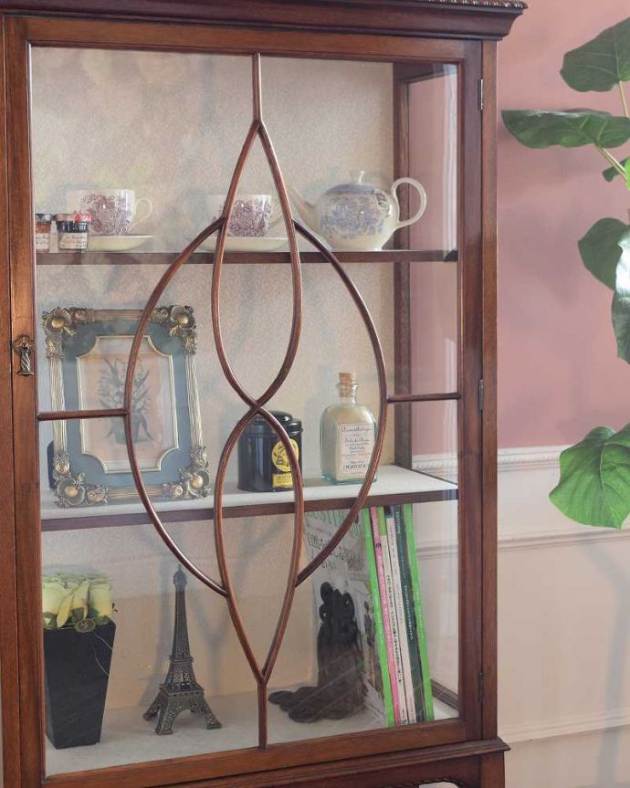 アンティークのキャビネット　アンティーク家具　高級なマホガニー材を使った英国家具、上品なアンティークのガラスキャビネット。木で描かれたガラス扉の模様の美しさにうっとり･･･まだ機械のない時代に、どうやって作られたんだろう…と不思議になるくらい美しいガラス面に描かれた美しい木の模様が特長。(q-1983-f)