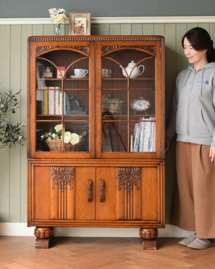 アンティークのキャビネット　アンティーク家具　イギリスアンティークの収納家具、お花の彫刻入りのブックケース（キャビネット）。英国らしい堂々とした風格のあるガラスキャビネット重厚感ある佇まいで、落ち着いた雰囲気を演出してくれる英国のキャビネット。(q-2044-f)