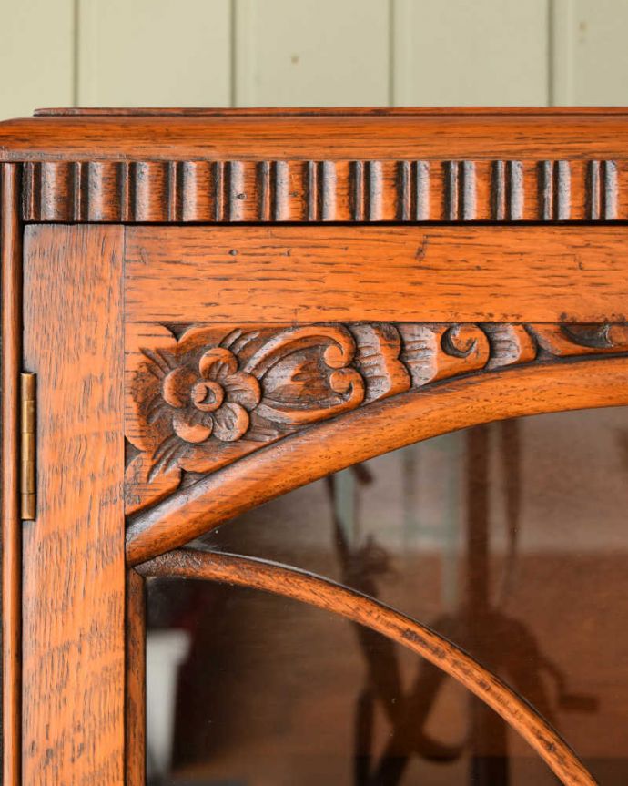 アンティークのキャビネット　アンティーク家具　イギリスアンティークの収納家具、お花の彫刻入りのブックケース（キャビネット）。惚れ惚れしちゃう美しさこんなに堅い無垢材に一体どうやって彫ったんだろう？と不思議になるくらい細かい彫にうっとりです。(q-2044-f)