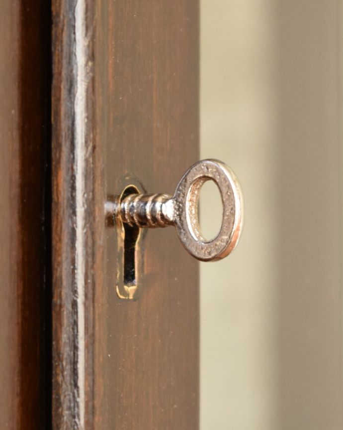 アンティークのキャビネット アンティーク家具 正統派の英国アンティークキャビネット、ポインテッドアーチの定番ガラスキャビネット 。開ける度にワクワクする取っ手鍵が取っ手になっているので、中を開ける度にまるで宝箱を開ける気分。(q-2076-f)