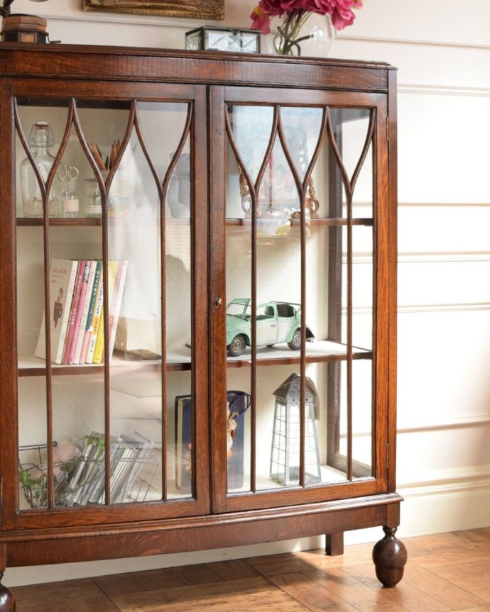アンティークのキャビネット　アンティーク家具　正統派の英国アンティーク、ゴシックデザインの定番ガラスキャビネット 。ガラス越しに見るお気に入りの美しさ…光をたっぷり取り入れてくれるガラス扉と棚板。(q-2077-f)