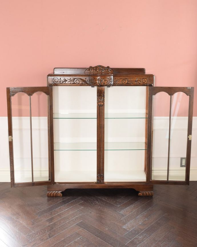 アンティークのキャビネット アンティーク家具 英国のアンティーク家具、お花の彫刻が華やかなアンティークのチャイナキャビネット。扉を開けると・・・めずらしいガラス棚板のチャイナキャビネット。(q-2083-f)