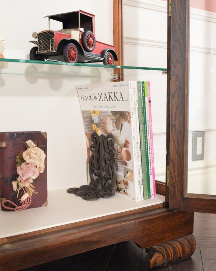 アンティークのキャビネット アンティーク家具 英国のアンティーク家具、お花の彫刻が華やかなアンティークのチャイナキャビネット。しっかり収納できますA4サイズの雑誌までしっかり収納出来ちゃう優れもの。(q-2083-f)