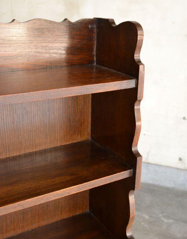 アンティーク家具 ダークブラウンのアンティーク家具、英国のブックシェルフ(本棚)。全体を縁どるカッティングがとっても素敵なシェルフです!このような凝った装飾はアンティークならではです。(q-458-f)