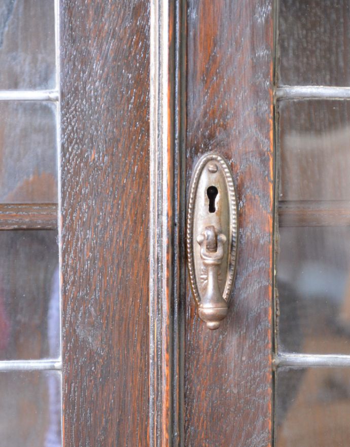 アンティークのキャビネット　アンティーク家具　和室にも似合うアンティークの英国家具、英国紳士たちが愛したガラス扉のブックケース（本棚）。扉には風合いのあるドロップ形の取っ手が付いています。(q-689-f)