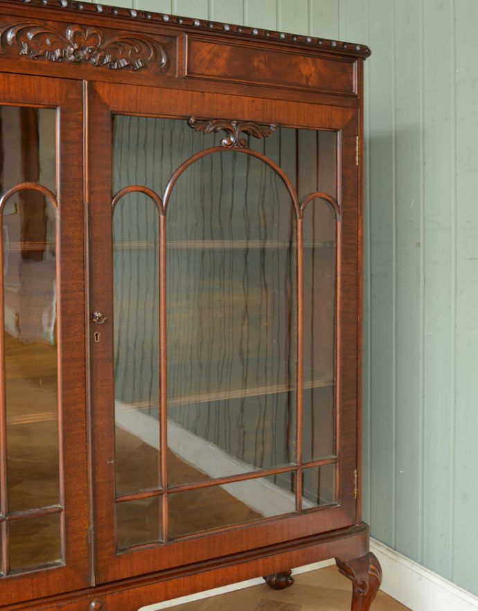 アンティークのキャビネット　アンティーク家具　マホガニー材の高級感たっぷりなアンティーク家具、グラスキャビネット（本棚）。木の装飾が上品なアクセントになっています。(q-721-f)