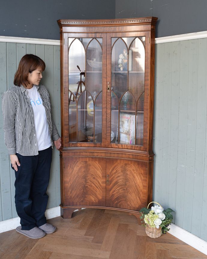 アンティークのキャビネット アンティーク家具 英国輸入のアンティーク家具、曲線が美しいコーナーキャビネット。お部屋の角にすっぽり収まる飾り棚!コーナーのオシャレにいかが?(モデルの身長は157cmです)。(q-976-f)