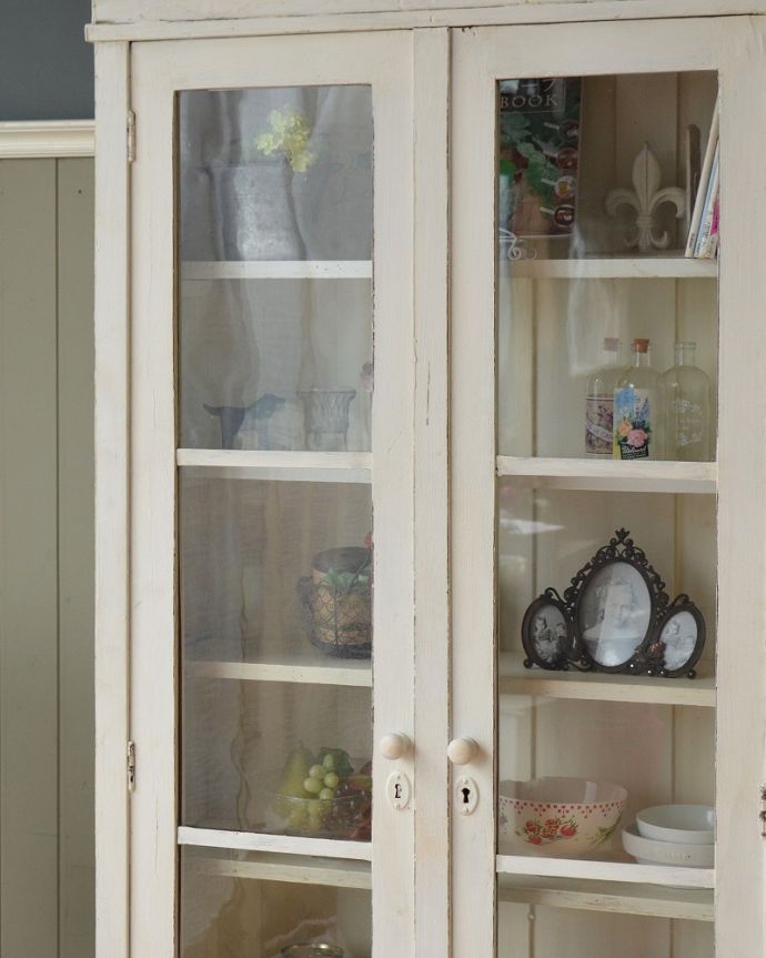 アンティークのキャビネット アンティーク家具 フランスのインテリアを楽しむアンティーク家具、ペイント仕上げのガラスキャビネット 。ガラス越しに中をのぞいてみると・・・昔、作られたアンティークのガラスは今のものと違ってゆらめきがあります。(x-1229-f)