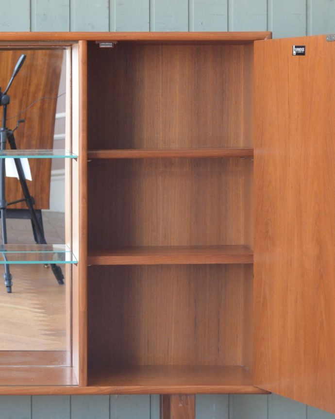 アンティークのキャビネット　アンティーク家具　イギリス輸入の北欧家具、ミラーバックのヴィンテージグラスキャビネット。扉の中も、ボディと同じチーク材の色味で統一されています。(x-947-f)