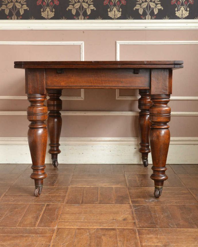 アンティークのテーブル アンティーク家具 アンティーク英国家具、キャスター付きのオーク材のドローリーフテーブル(伸張式テーブル)。こちら側から見てみると・・・アンティークは新品ではないので経年変化によるキズはありますが、専門の職人がしっかり修復しました。(z-042-f)