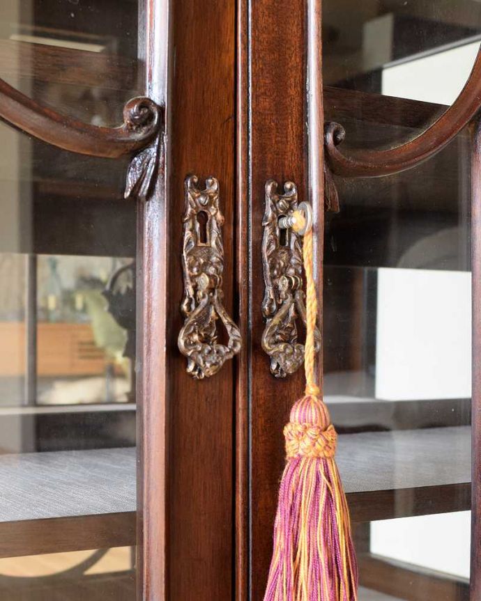 アンティークのキャビネット　アンティーク家具　マホガニー材のアンティーク英国家具、装飾が美しいガラスキャビネット（ショーケース）。開ける度にワクワク取っ手もアンティークらしいデザイン。(z-048-f)