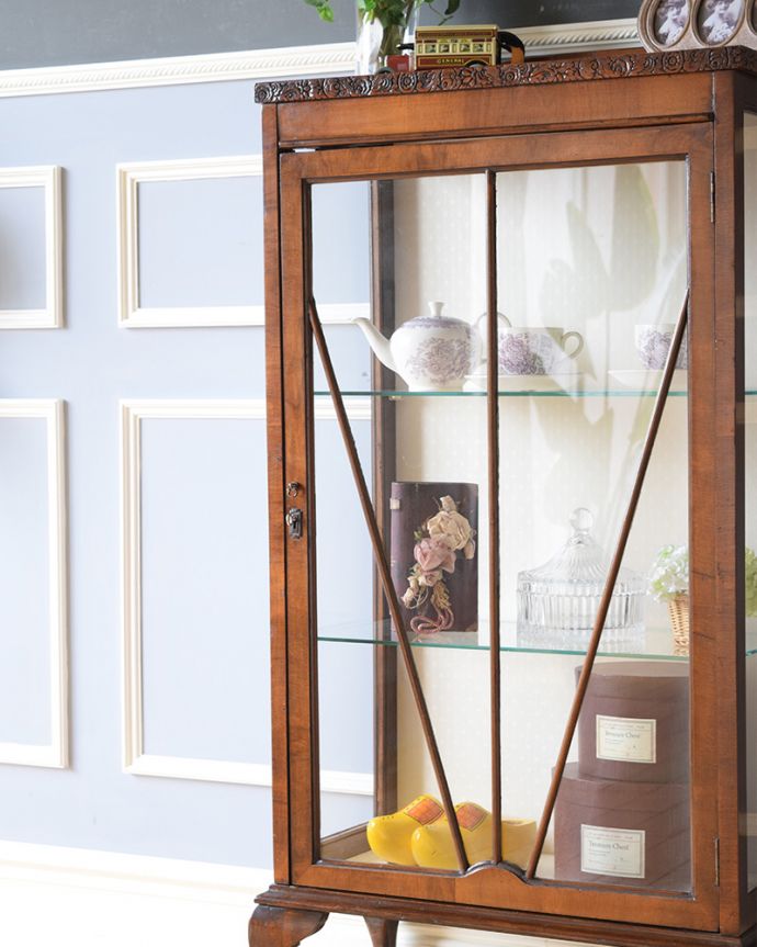 アンティークのキャビネット　アンティーク家具　コンパクトなアンティーク家具、お花の彫りが美しいウォルナット材のガラスキャビネット。ガラス越しに中をのぞいてみると･･･中に入れたものが、なんだかちょっと高級に見えちゃうんです。(z-052-f)