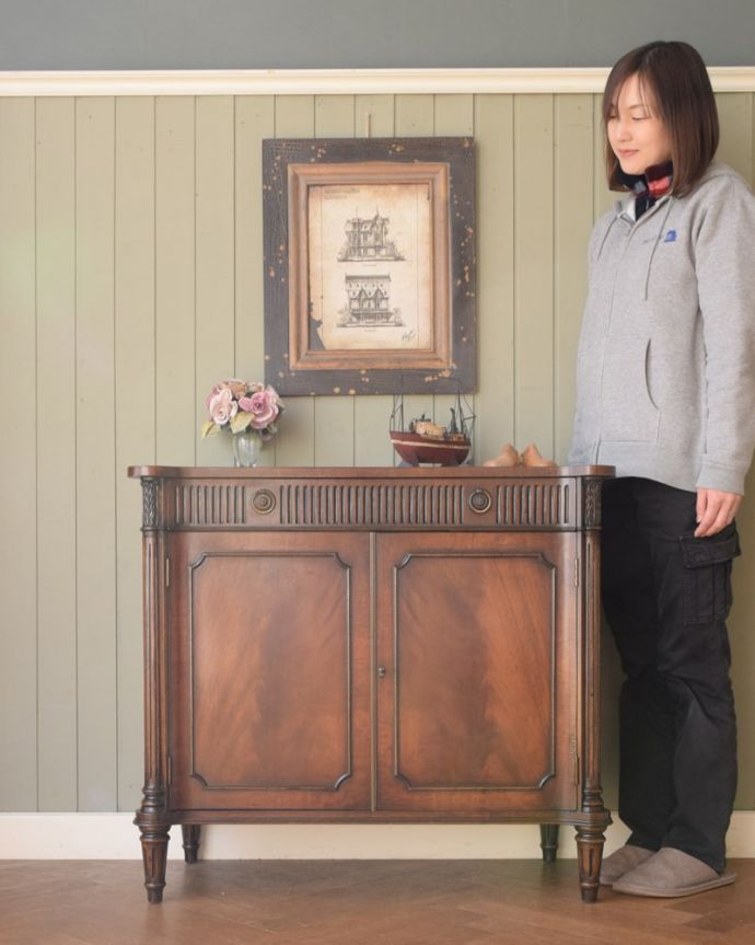 アンティークのキャビネット　アンティーク家具　イギリスのオシャレなアンティーク家具、マホガニー材が美しいサイドボード。引き出しと扉、両方の収納が付いた便利な家具扉と引き出し両方の収納が付いた便利なアンティークです（モデルの身長は165cmです）。(z-107-f)