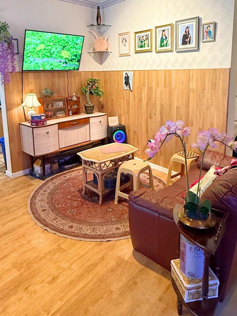 2024年のグエン家のリビング。カラオケ画面と家族写真、温かみのあるインテリア