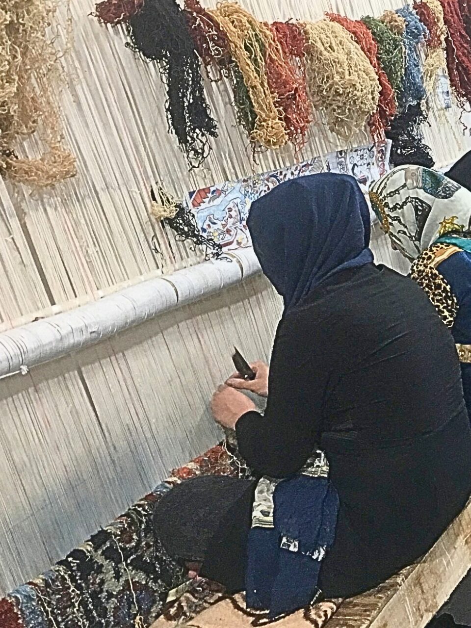 ペルシャ絨毯を手結びしている人