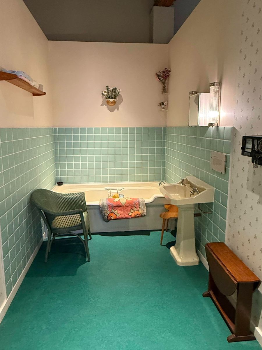 1956年の共用バスルーム。緑のタイルとバスタブ