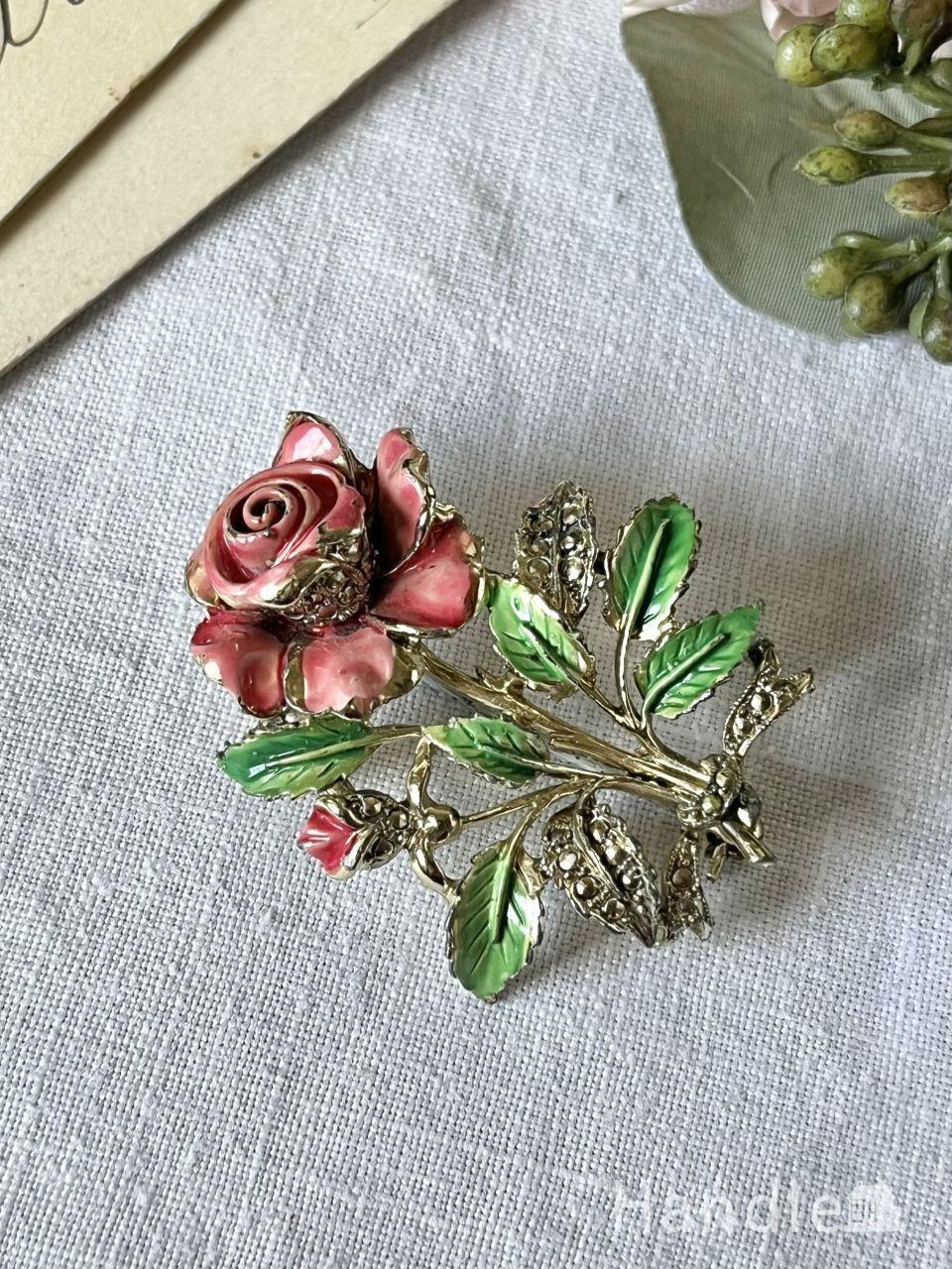 華やかに咲き誇る赤い色の薔薇の花、イギリスで見つけたビンテージのブローチ