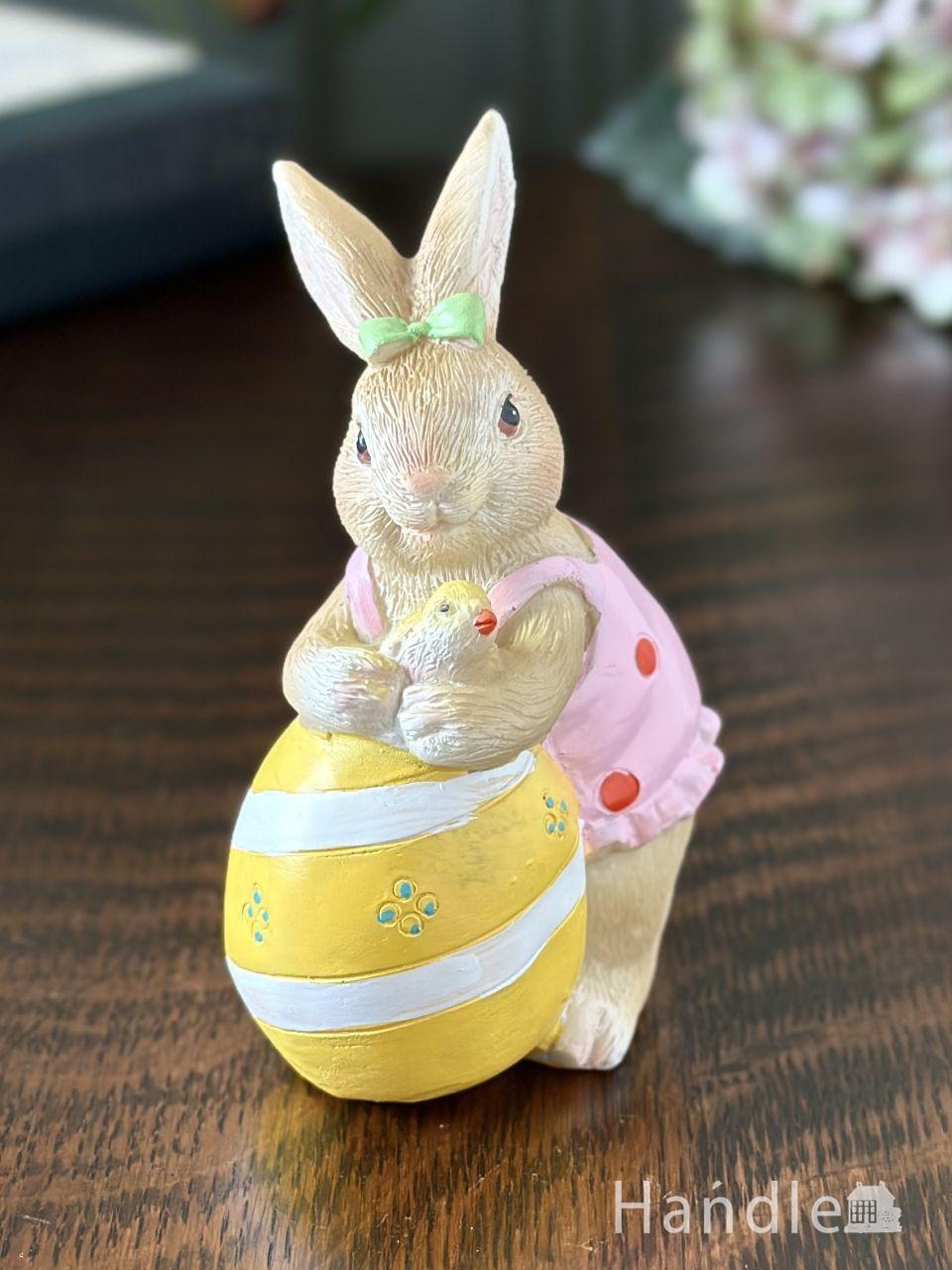 イエロー色のタマゴで遊ぶウサギのオブジェ、春の訪れを喜ぶイースターエッグ