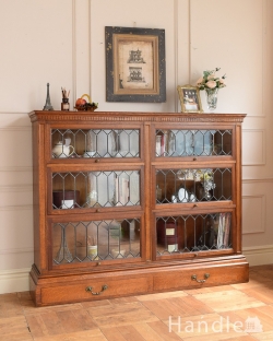 アンティーク家具 アンティークのキャビネット 美しい格子デザインのガラス扉がキラキラ輝くアンティークの英国家具、フラップ扉のブックケース