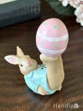 春の訪れを感じるイースターラビット、ピンクのタマゴと遊ぶウサギのオブジェ