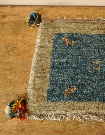 こちらは「鹿と生命の木」の模様が編まれています。鹿には、子供を大切に育てる生態から「家庭円満」という願いを込めて造られたもの。生命の木には、長寿・健康への願い。そして、子供の成長を願う気持ちが込められています。(b-108) b-108 オールドギャッベのミニマット