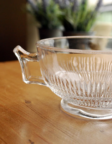 アンティーク 雑貨のガラス小物　アンティーク雑貨　持ち手のついた可愛いアンティークプレスドグラスのガラスボウル。食事の時間を楽しく過ごすために作られた器貴重だったガラスがプレスドグラスの発達によって気軽に手に入るようになった時代に作られたテーブルウェア。(pg-1139-2)