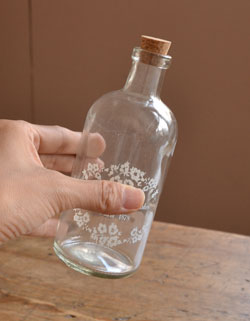 リビング雑貨　インテリア雑貨　アンティーク風ボトル（プリント）。クリアガラスにお花のリースが入った可愛いボトルです。(n14-017)